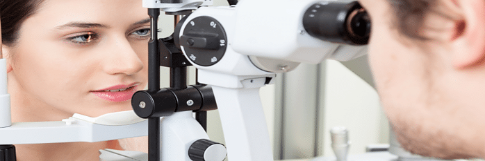 optometrist examining patient with slit lamp