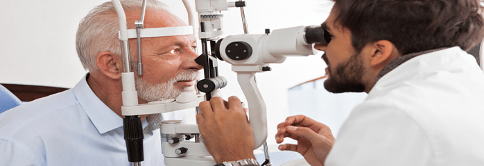 optometrist examining patient with slit lamp