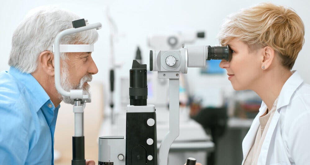 optometrist examing man in slit lamp